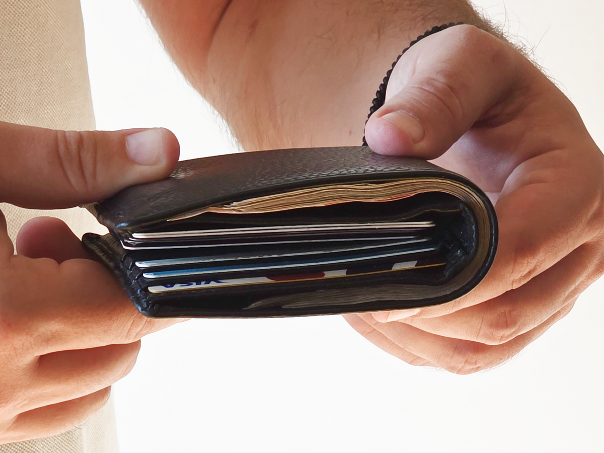 Bulky leather wallet packed with cards and cash before switching to Zade